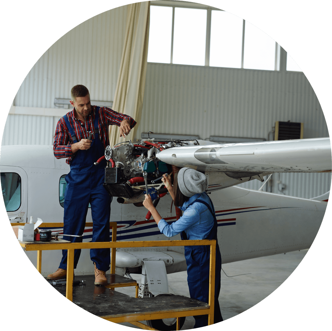 Two people working on an airplane's wing