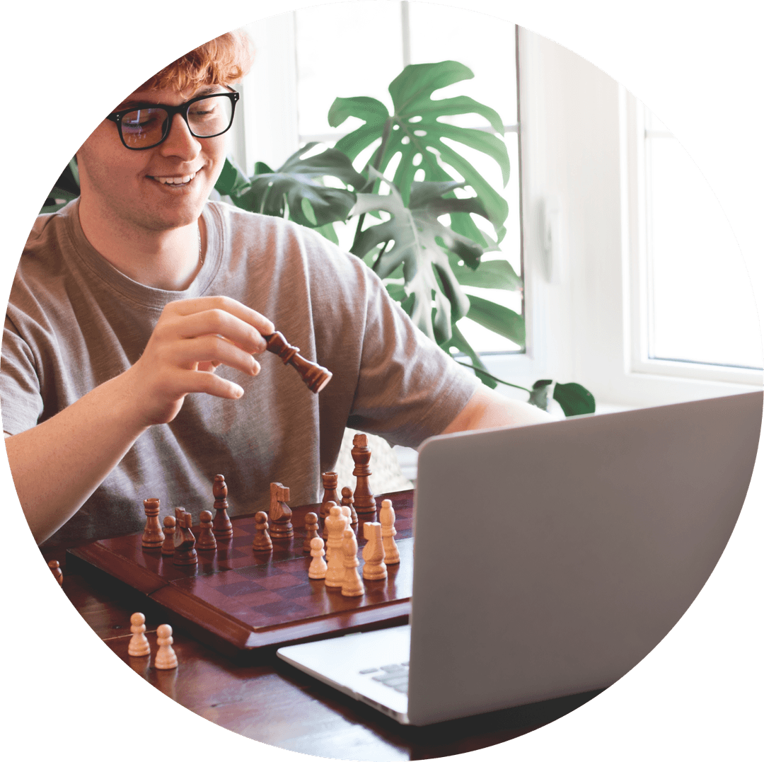 Person playing chess in front of a laptop